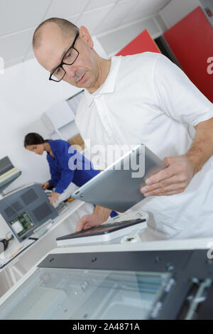 man reading instruction for 3d printer on tablet computer Stock Photo