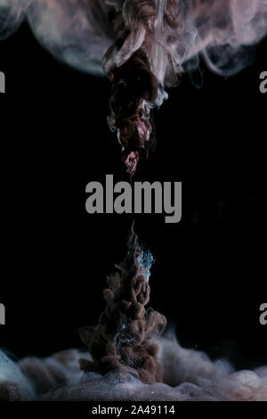Antimatter explosion, a surreal fantasy collage with curly clouds of black smoke on a black background. Stock Photo