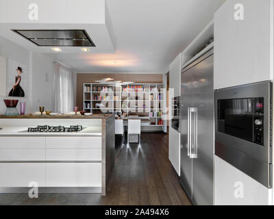 interior shot of a modern kitchen overlooking on hte dining room the floor is made of wood Stock Photo