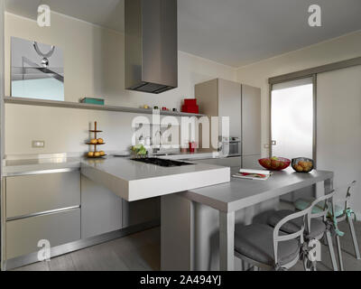interiors shots of a modern kitchen with kitchen island and snack table the floor is made of wood Stock Photo