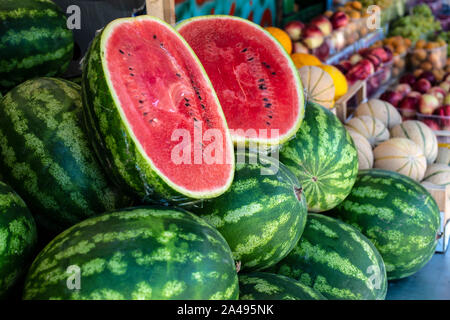 Watermelons on shelf. Cutted watermelon on street market. Summer Fruits. Stock Photo