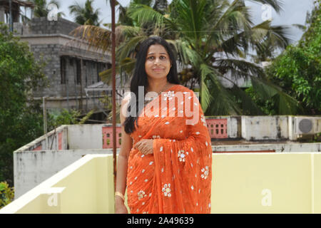 Portrait of a beautiful young adult indian female model in a traditional indian dress wearing saree. Stock Photo