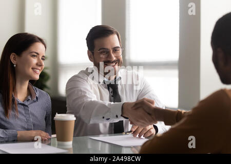 Happy hr manager welcoming african american employee at new job. Stock Photo