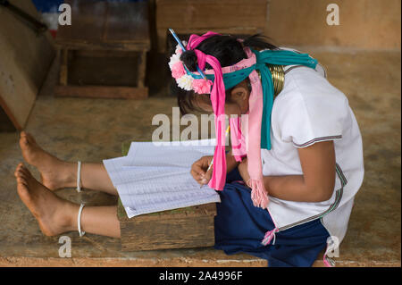 Chiang Rai, Thailand - June 06, 2011: Teenager student girl from the Kayan Long Neck Hill tribe writing on notebook, at the school Stock Photo
