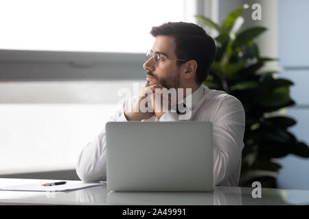 Distracted from job millennial businessman looking aside. Stock Photo