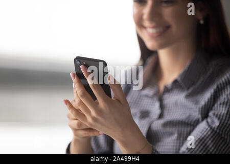 Close up happy young woman holding smartphone. Stock Photo