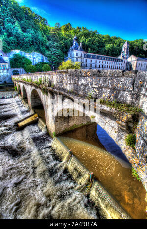 Brantome en Perigord, France. The Pont Coude (Right Angle Bridge) over the River Dronne, with the Abbey of Brantome in the background. Stock Photo