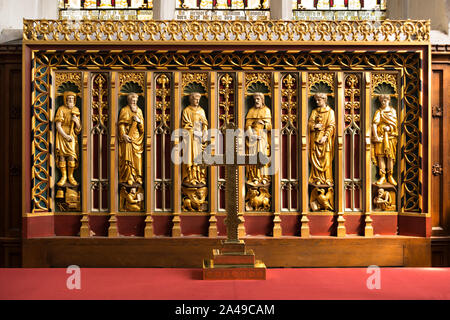 Crucifix and ornate carved wooden Reredos panel depicting six Christian Saints in St Dunstan's Chapel, Leicester Cathedral, Leicester, England, UK Stock Photo