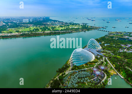 Singapore Gardens by the Bay botanical gardens aerial view and Marina Barrage dam with ship tankers in open sea. Stock Photo