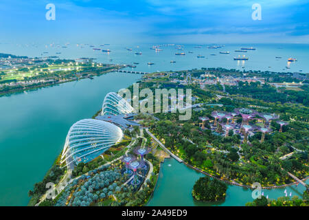 Singapore Gardens by the Bay botanical gardens aerial view and Marina Barrage dam with ship tankers in open sea. Stock Photo