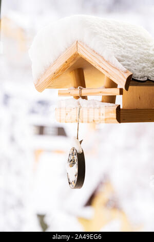 Snow covered wooden birdfeeder in winter. Stock Photo