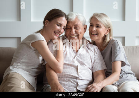 Cheerful three-generation family sitting on couch enjoy time together Stock Photo