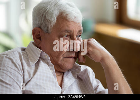 Sad grandfather put head on hand lost in thoughts Stock Photo