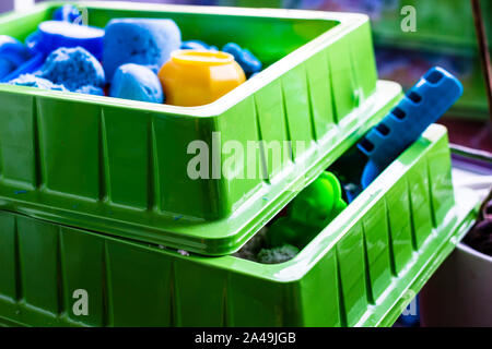 Two containers with kinetic sand and plastic toys for the development of fine motor skills and creative imagination in children. Close-up. Stock Photo