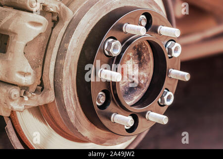 wheel spacer with studs for the car mounted on the wheel hub auto tuning, close-up. Stock Photo