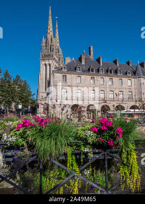 Quimper Musée des Beaux-Arts and Saint Corentin Quimper Cathedral behind viewed from River Odet with street flowers in foreground Brittany France Stock Photo