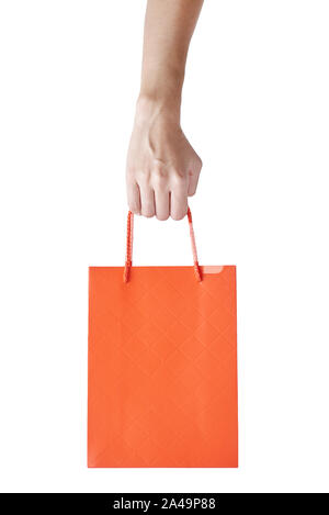 Woman hand hold red empty blank craft paper shopping bag isolated on a white background. Packaging template mockup Stock Photo