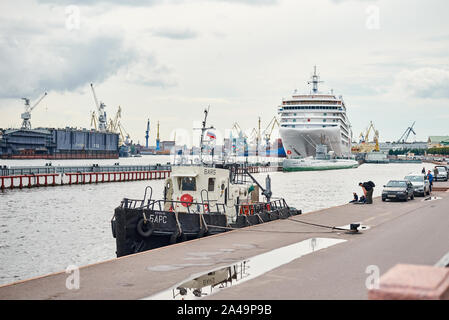 cargo ship in port against working crane bridge Stock Photo