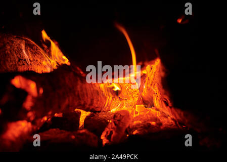 Close up of bonfire with sparks at night. Heat from burning logs and coals in the dark Stock Photo
