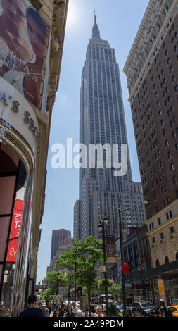 Upright shot of Empire State building seen from ground level, squeezed between two buildings Stock Photo