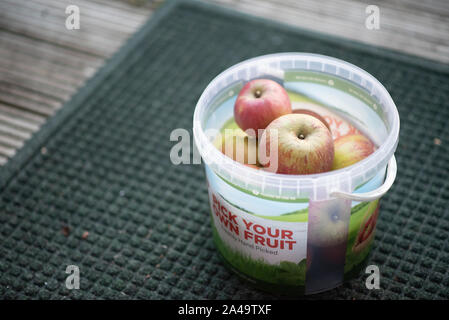 London, United Kingdom - September 15, 2019: British apples sit in a small bucket that says “Pick Your Own Fruit” after being picked on a farm in Kent Stock Photo