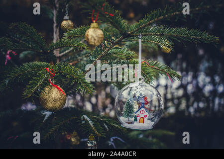 Transparent cristalball with christmas tree and house inside. Snow in christmas ball. Stock Photo