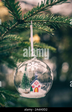 Transparent cristalball with christmas tree and house inside. Snow in christmas ball. Stock Photo