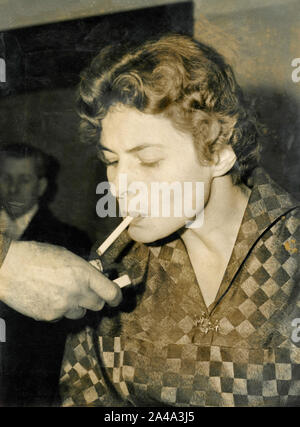 Swedish actress Ingrid Bergman lighting a sigarette, 1950s Stock Photo