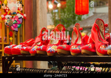 Traditional red Chinese embroidered shoes displayed in the store Stock Photo