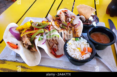 Fresh chicken tacos served on flour tortillas with refried beans and rice Stock Photo