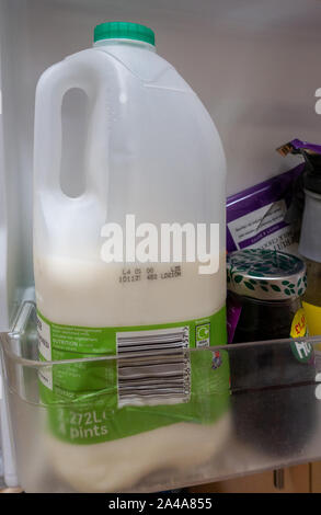 Closeup of half full plastic milk bottle in a fridge door Stock Photo
