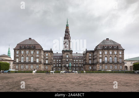 Copenhagen, Denmark: White horses exercise in front of Christiansborg Palace that's situated on the islet of Slotsholmen in the capital city. Stock Photo