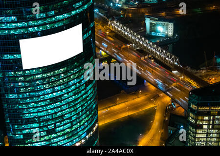 Blank isolated white screen billboard on building at night - mockup Stock Photo