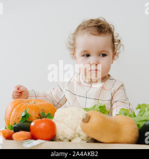 Thoughtful girl with vegetables. Square close-up shot  Stock Photo