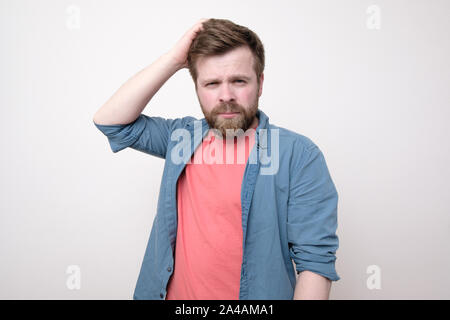 Thoughtful, concerned bearded man narrowed his eyes and looks into the camera. Isolated on white background. Close-up. Stock Photo