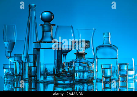 Glassware and alcoholic beverages on a glass table in bar. Stock Photo