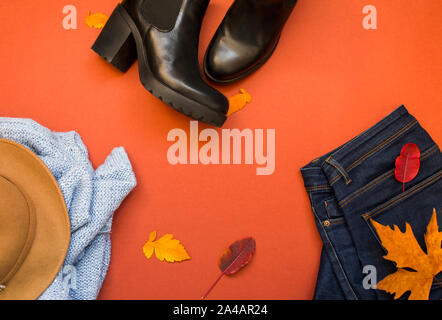 Female clothes outfit - blue sweter and jeans on a terracote background, top view. Winter, fall woman clothing Stock Photo