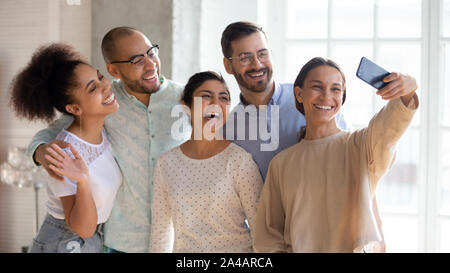 Smiling diverse friends taking selfie, posing for photo together Stock Photo