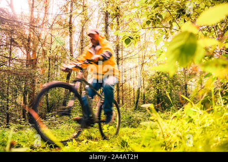 Cycling Ireland. Blurred recreational cyclist on mountain bike in the forest trail.