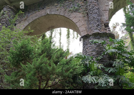 Looking at an old arch from green park. This scene was taken near to the Church of our Lady of Monte in Nossa Senhora Do Monte, Madeira, Portugal Stock Photo