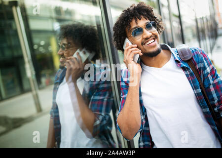 Handsome hipster man with beard in town calling on mobile phone Stock Photo