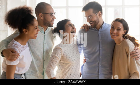 Happy diverse friends standing together, embracing, having fun Stock Photo