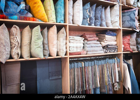 Bright pillows, towels, plaids, blankets and other home wear on shelves Stock Photo