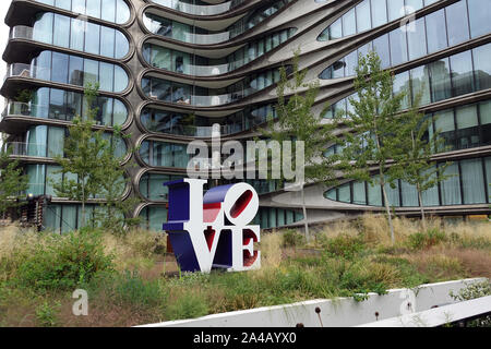 08 September 2019, US, New York: A residential building by star architect Zaha Hadid, who died in 2016, stands right next to High Line Park. In front of it stands the famous 'Love' sculpture of Robert Indiana. The High Line Park is a preserved but no longer used elevated railway line in the west of Manhattan. The first construction phase was opened in 2009. It is one of the newest and most unusual parks in New York and already a sight to behold. It is almost three kilometres long and only about 20 metres wide. High Line is located 10 meters above the road between 10th and 11th Avenues and goes Stock Photo