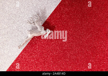 Christmas reindeer on silver and red glitter background, view from above with place for text. Stock Photo