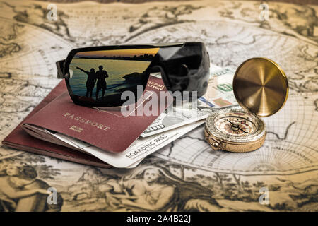 Travel planning concept, destination tropical scene in glasses reflection. Passport with tickets, money and compass on old blurred map Stock Photo