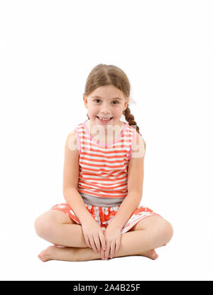 Young girl sat on floor looking at camera on isolated white background Stock Photo