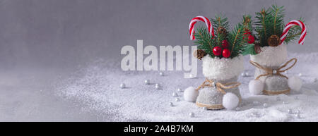 Little Christmas tweed retro boots with fir tree branches, cones and candies, selective focus, banner Stock Photo