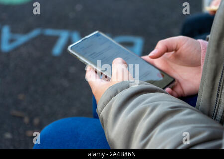 a womans hands holding a mobile phone or cell phone Stock Photo