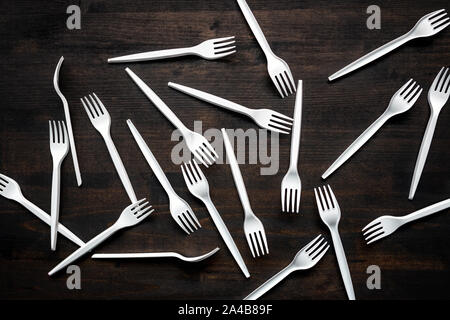 Plastic forks scattered on wooden table, top view Stock Photo